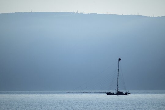 Felcua, Ferdilux or felucca with a tall mast, long gangplanks and a lookout platform for several people, a lookout boat, specially designed for hunting swordfish (Xiphias gladius), Strait of Messina, with Sicily in the background, Italy