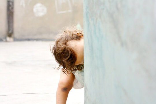 Toddler playing hide and seek.