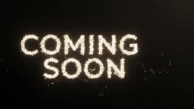 Coming soon announcement text is rendered in a glowing sparkler style against a black background.