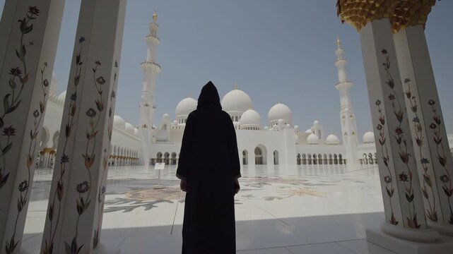 Woman in Black Abaya Framed by Columns at Sheikh Zayed Grand Mosque