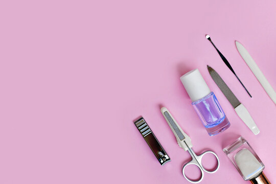 Manicure set and nail polish on side of pink background with copy space