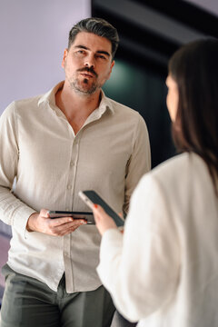 Business colleagues discussing work using digital devices