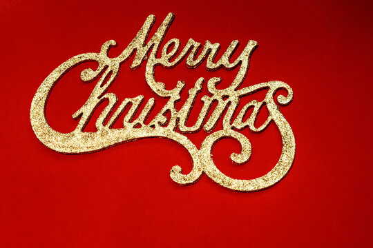 Merry christmas golden glitter typography greeting card on red background