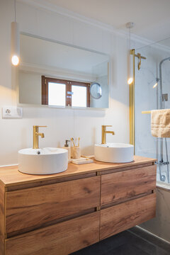 Modern apartment bathroom with double vanity and gold fixtures