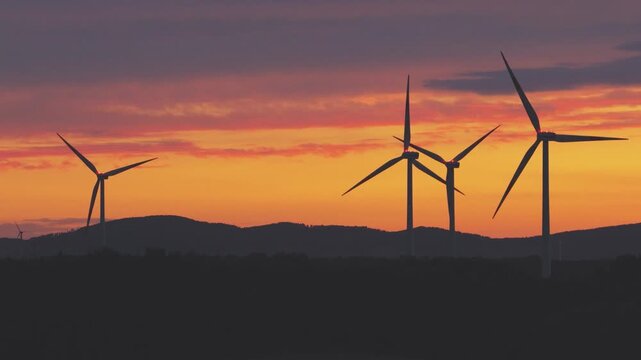 Renewable Wind Energy Farm with Multiple Turbines Against Dramatic Sunset Sky
