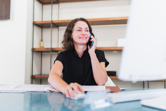 Woman smiling while talking on phone at clinic reception