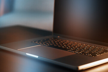 Laptop on a table during evening hours with dim lighting in a home office setting © fotofabrika