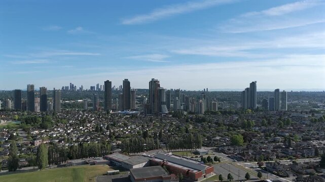 Ecole Alpha Secondary School With High-rise Buildings In Brentwood Neighborhood InThe Background In Burnaby, British Columbia, Canada. - aerial shot
