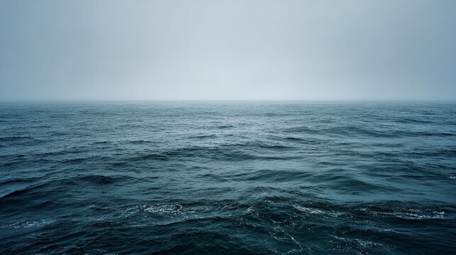 A serene and tranquil wide cinematic shot of a calm, featureless expanse of ocean viewed under a soft, misty atmosphere, highlighting gentle waves and a muted color palette that evokes peace and solit