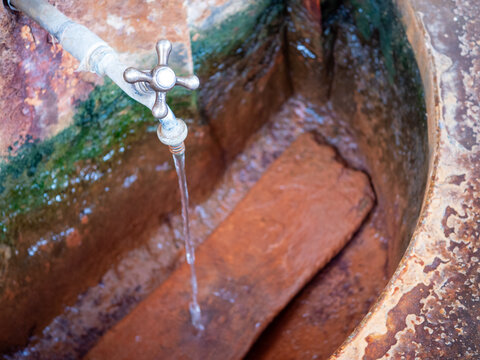 Natural healing mineral spring flowing from a metal tap in Bardejov Spa, Slovakia, representing spa treatment, drinking cure, balneotherapy, mineral water and health tourism.