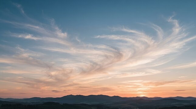 Vast Panoramic Sky with Wispy Clouds at Sunset Over Rolling Hills.