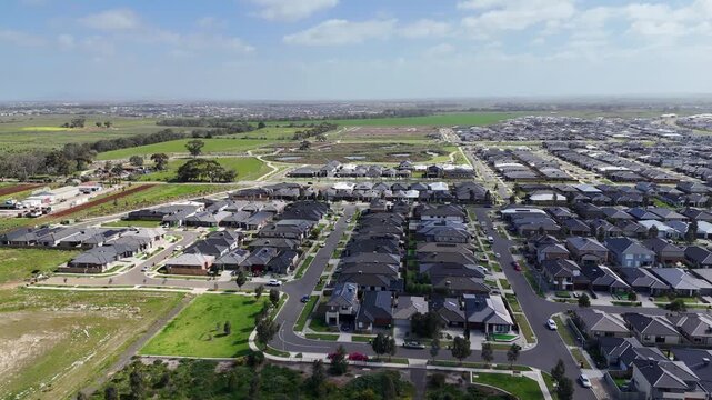 Aerial vista over the master-planned growth corridor of Tarneit, with new residential housing estates, street grids, and agricultural fringe land. Outer suburb expansion in Melbourne, Australia.&nbsp;