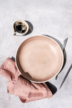 Empty pink plate with spoon and coffee cup overhead