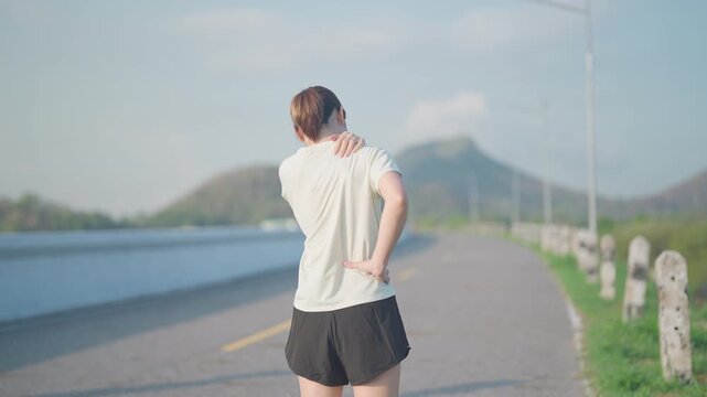 Adult female runner with back, shoulder and waist ache due to piriformis syndrome and low back pain. Woman having muscle injury or spinal compression during running. Sports and medical concept