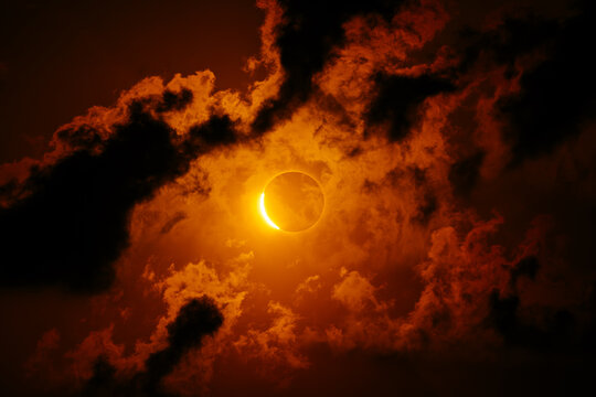 Solar eclipse with fiery clouds and dramatic dark sky