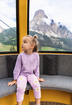 Young girl look through cable car window in Dolomites