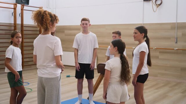 Teacher explaining gymnastics exercise to students