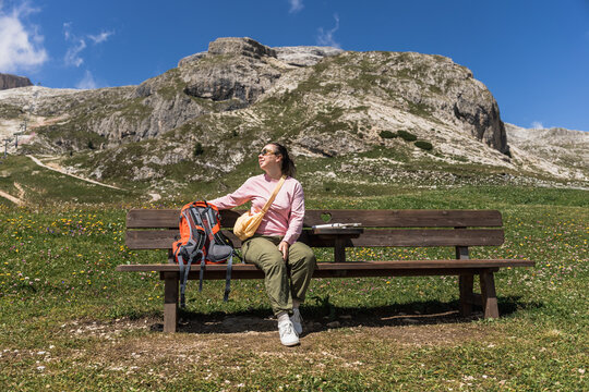 Female hiker resting on bench in the Dolomites