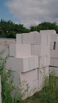 Stacked white aerated concrete blocks at a construction site, illustrating lightweight masonry materials, wall construction, insulation and modern housing development.