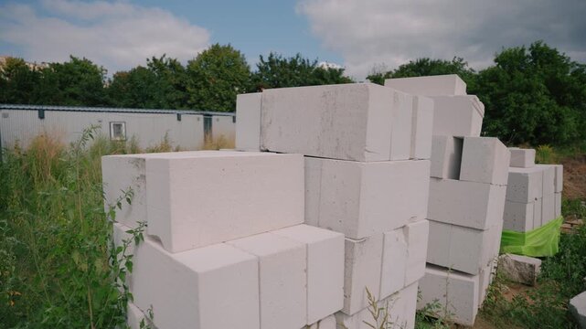 Stacked white aerated concrete blocks at a construction site, representing modern masonry, wall construction, thermal insulation and efficient residential building materials.