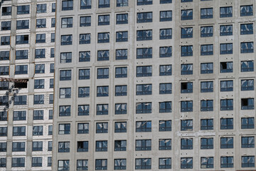 New high-rise building under construction reveals empty windows and incomplete facade in a bustling urban landscape © beholdereye