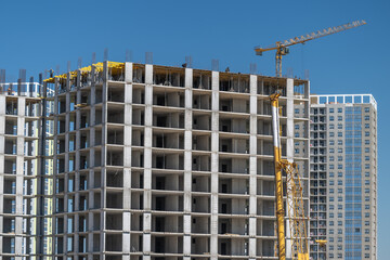 Construction workers diligently building a high-rise structure under a clear blue sky in a vibrant urban landscape © beholdereye