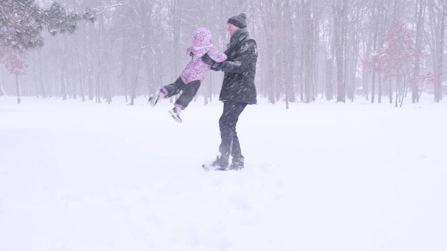Father winter activity. Toddler enjoying playful lifting outdoors. Active fatherhood concept.