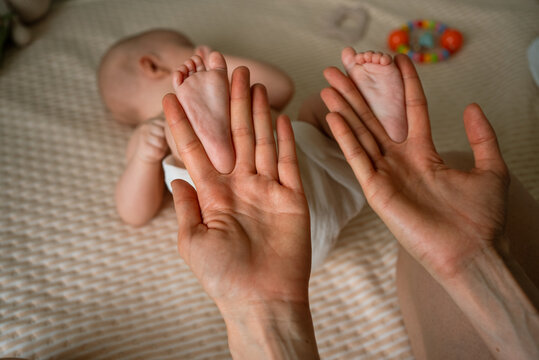 Mother's hands cradling tiny newborn feet, conveying tender bond, protection and affection in a close, intimate moment of early parenthood and family connection