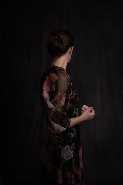 dark painterly renaissance studio portrait of woman turning her head away