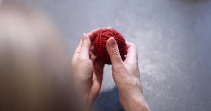 Hands holding red yarn and a crochet hook, crafting detail. hands, 
