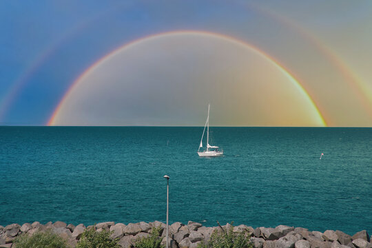 Double Rainbow over the Sea with Sailboat off the Coast