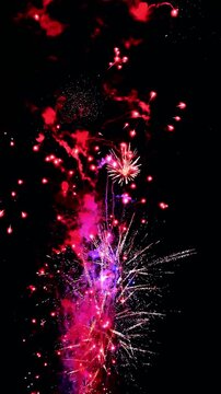 4K. Vertical loop seamless of real fireworks background golden shining fireworks with bokeh lights in the night sky. glowing fireworks show. New year's eve fireworks celebration multiple colors 