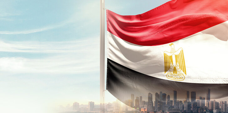 Egypt national flag wavering in beautiful clouds with building skyline. Modern Building skyline with national flag. Egypt national flag for independence day.