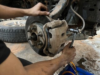 Car suspension and brakes  Mechanical view of suspension coil spring, control arm, and disc brake assembly without wheel. © Phaimanee