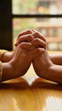 Warmly Intertwined Hands on radiant golden wood, cinematic macro with soft shallow depth of field, perfect for empathy and unity campaigns.