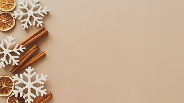 Flat lay christmas decoration with snowflakes and cinnamon sticks on a beige background