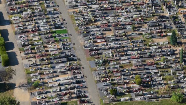 Aerial view flying over large cemetery with many gravestones and headstones