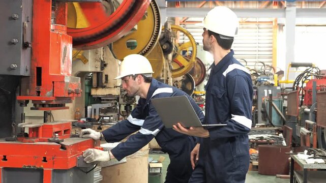 professional mechanical engineer technician protective overall hardhat collaborate inspect heavy industrial machinery  check diagnostic data laptop computer during maintenance operations inside metal 