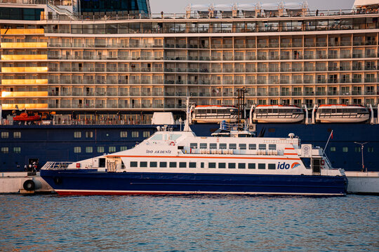 View of IDO Akdeniz passenger ferry in front of cruise ship in Kusadasi. Kusadasi, Turkiye - August 21, 2026.