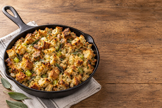 Golden herb bread stuffing in a cast iron skillet with Thanksgiving copy space