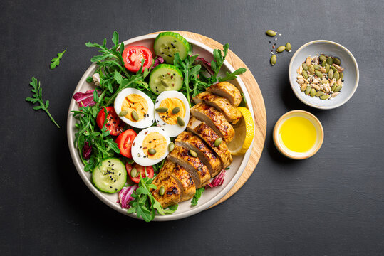 High protein lunch bowl with chicken, eggs and vegetable salad.