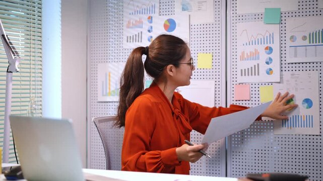 Self assured professional woman reviewing data graphs in a contemporary office setting