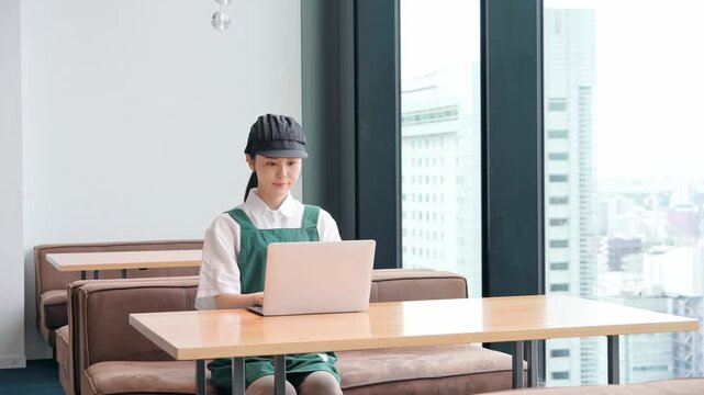 ノートパソコンでデータ入力する飲食店店員