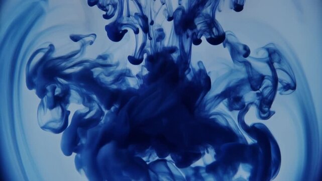 Deep indigo ink diffusing across the surface of still water in slow marbled patterns