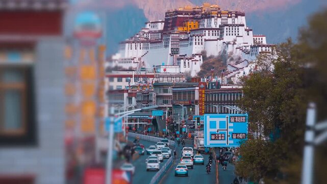 Potala Palace in Lhasa Tibet with city street traffic and mountain backdrop, tilt-shift cinematic view