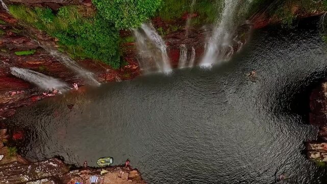 Aerial drone view of a stunning waterfall cascading into a natural swimming pool in the Brazilian jungle of Chapada dos Veadeiros, Goias