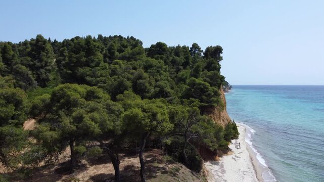 Scenic Mediterranean Coastline and Woman Walking on a Sandy Beach in Kassandra Greece, Aerial