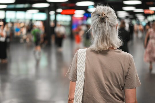 Caucasian senior woman walking inside airport during evening time - Urban lifestyle concept - UGC content - Main focus on head