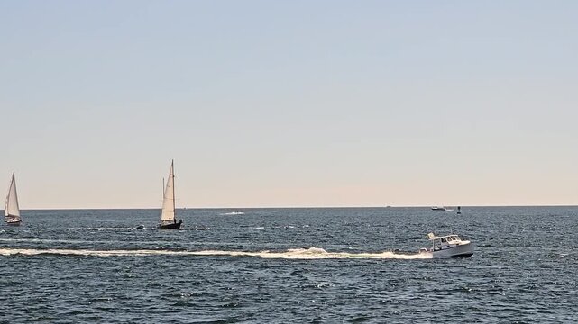 Sail boats and power boat on Casco Bay near Portland, Maine