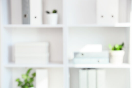 Corporate office organization and workspace productivity, blurred background of white shelves with binders and plants in a modern professional interior